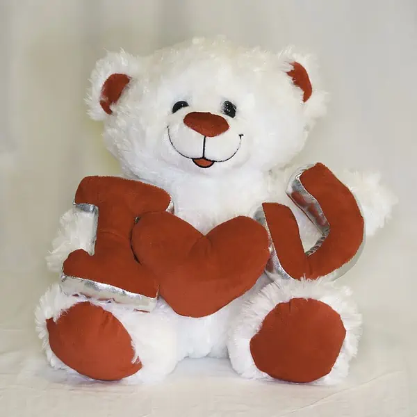בובת דובי פרוותי בצבע לבן ואדום. הדובי מחזיק בידיים את הכיתוב I LOVE U בצבע אדום. גודל הדובי 29 ס"מ.