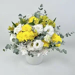 סידור פרחים מתנה מהשמש הו סידור פרחים בצבעים של צהוב ולבן. שזור מפרחי ליזיאנטוס לבן, חרציות צהובות ולבנות, גיבסנית לבנה, אלסטורמירה צהובה ואקליפטוס סילבר. צולם בתוך כלי לבן על רקע לבן.